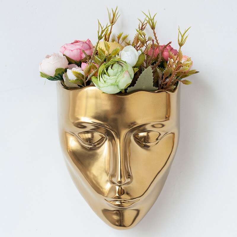 Hanging golden vase in the shape of a face